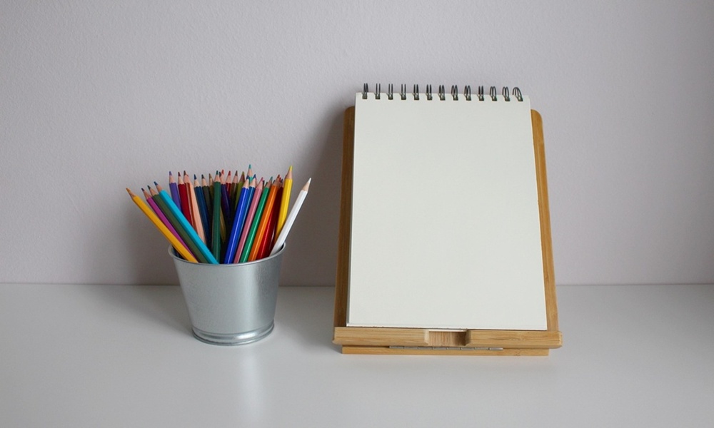 책상 위 색연필과 메모패드 이미지